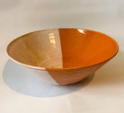 Stoneware bowl with a dipped glaze effect in orange and cream by Frankie Atkinson