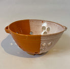 Small stoneware colander for washing small fruits and veg by Frankie Atkinson. Orange and cream dipped glaze.