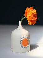 Small porcelain vase decorated with an orange painted dot and two circles by Ali Tomlin