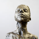 Close up of bronze sculpture sitting in contemplation by Carol Peace.