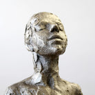 Close up of bronze sculpture sitting in contemplation by Carol Peace.