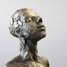 Close up of bronze sculpture sitting in contemplation by Carol Peace.