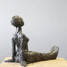 Close up of bronze sculpture sitting in contemplation by Carol Peace.