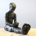 Bronze sculpture of girl reading a book by Carol Peace