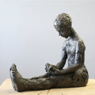Bronze sculpture of girl reading a book by Carol Peace