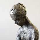 Close up of bronze sculpture of girl reading a book by Carol Peace
