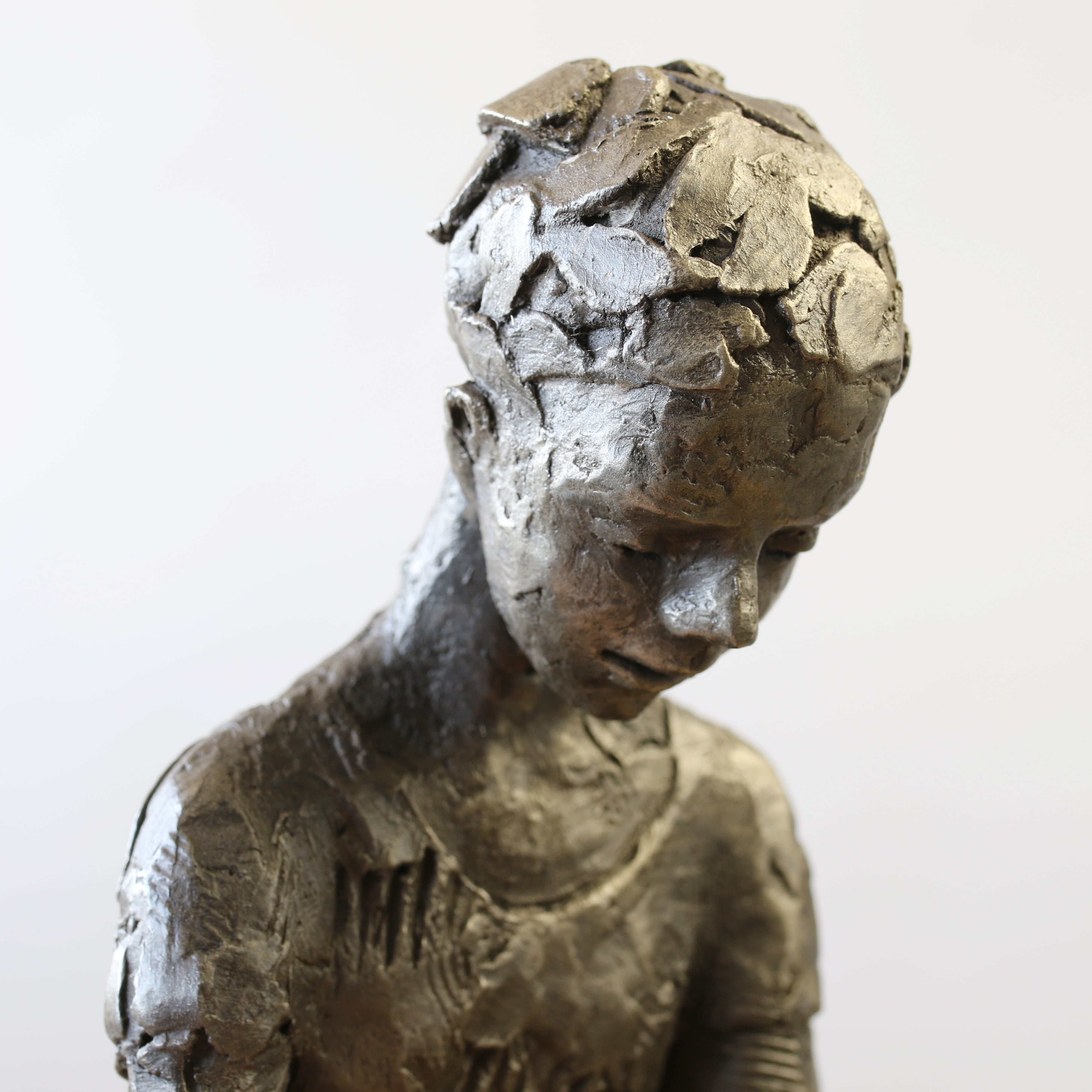 Close up of a Bronze sculpture of girl reading a book by Carol Peace
