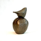 Small bronze sculpture of bird sitting on apple by Caro Burberry