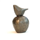 Small bronze sculpture of bird sitting on apple by Caro Burberry