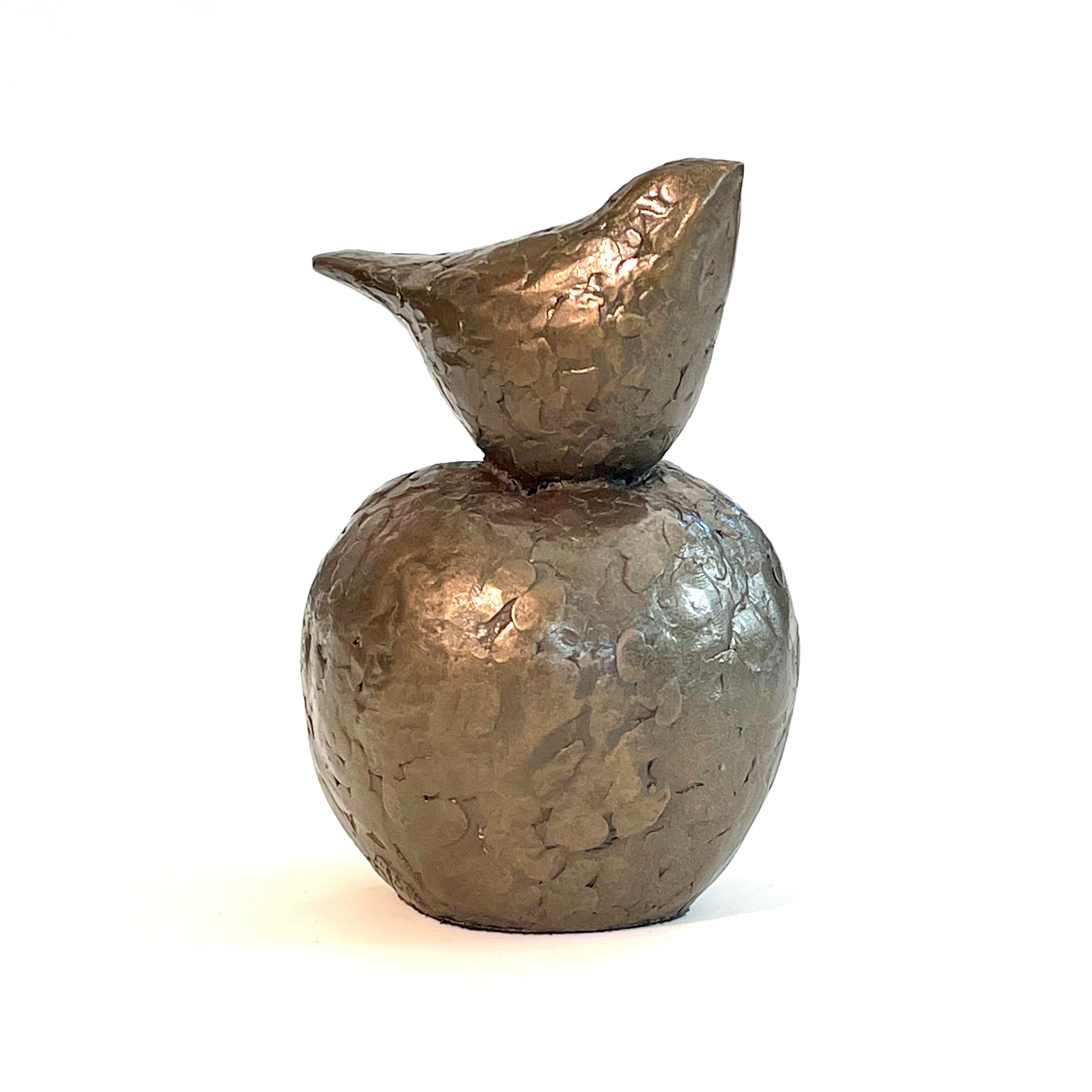 Small bronze sculpture of bird sitting on apple by Caro Burberry
