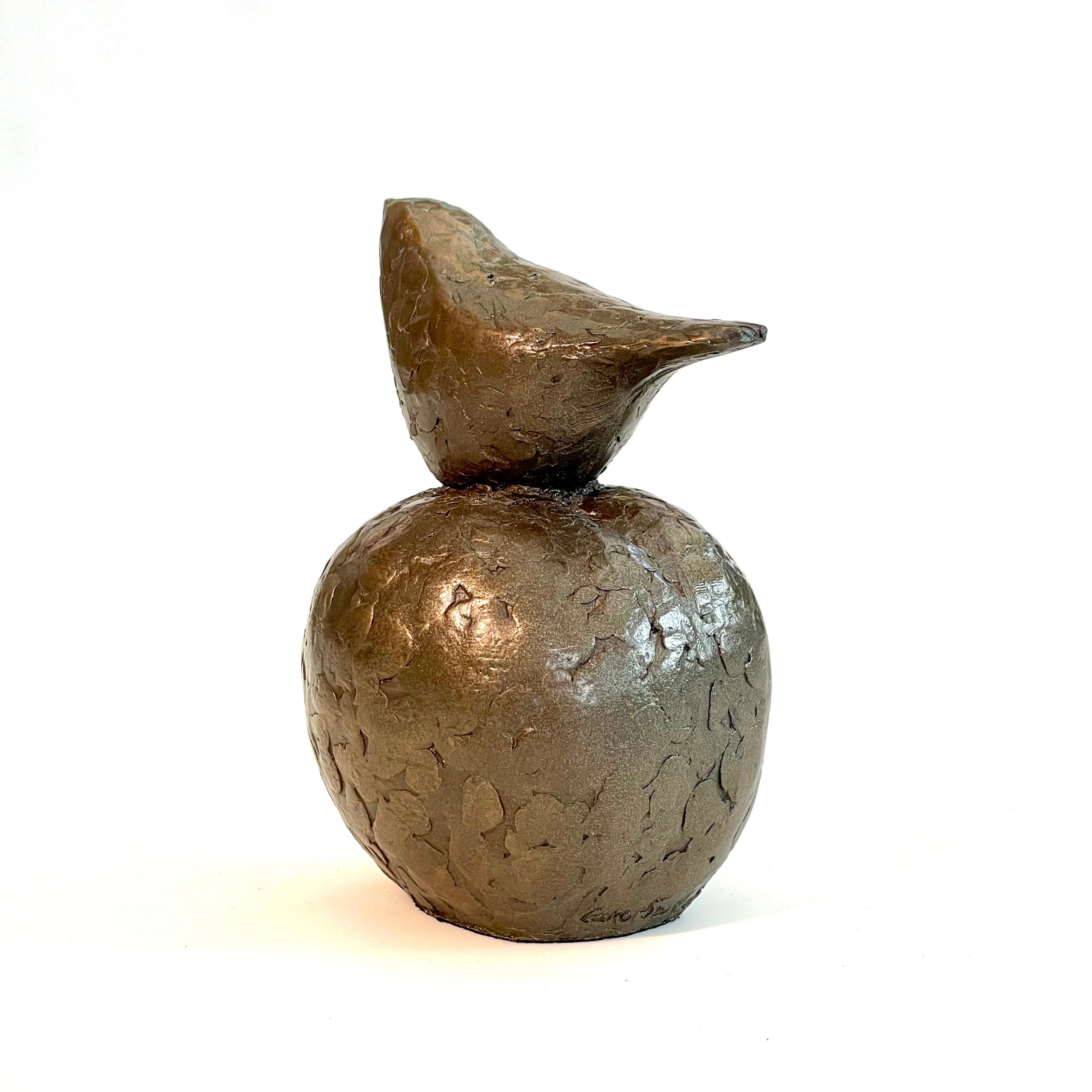 Small bronze sculpture of bird sitting on apple by Caro Burberry