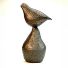 Small bronze sculpture of bird sitting on pear by Caro Burberry