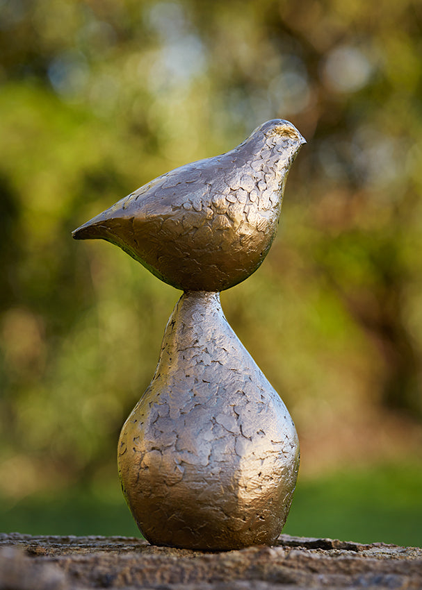 Small bronze sculpture of bird sitting on pear by Caro Burberry