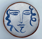 Earthenware decorative plate of face by Kate Reynolds.