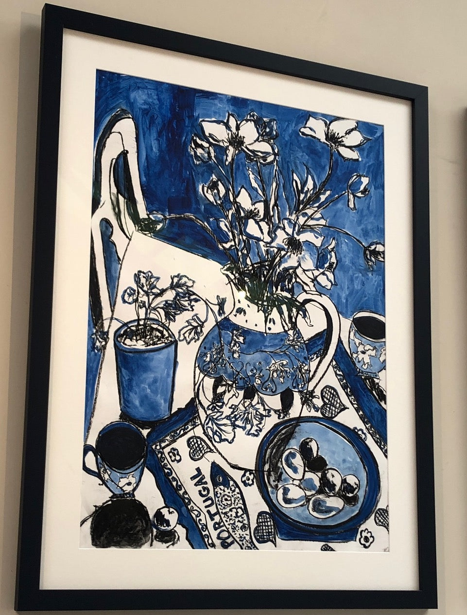 Painting in blue of table scape with decorative vase and flowers and Portugal towel