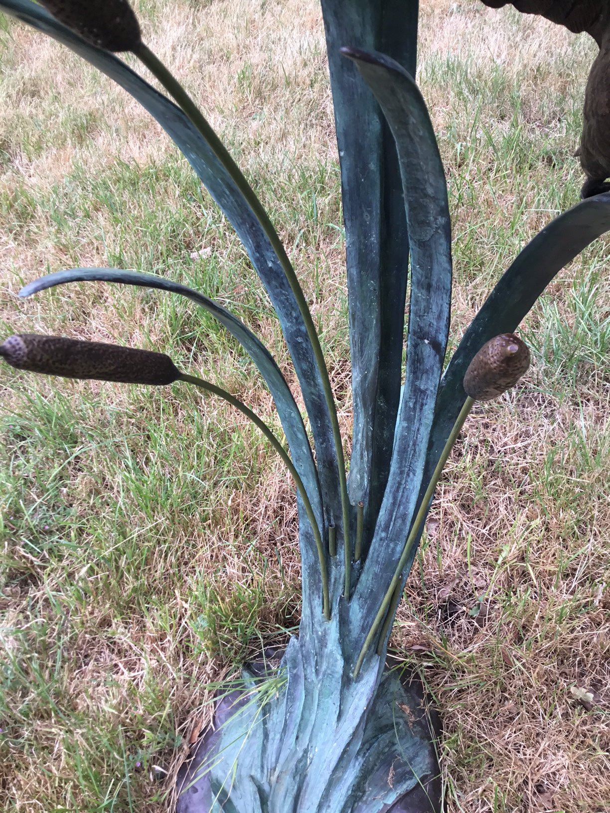 Close up of reeds on garden sculpture of ducks in flight by John Cox