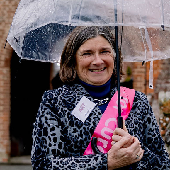 Portrait of team member Suzi Clogg holding an umbrella