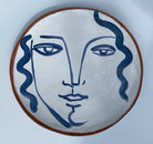 Earthenware decorative plate of face by Kate Reynolds.