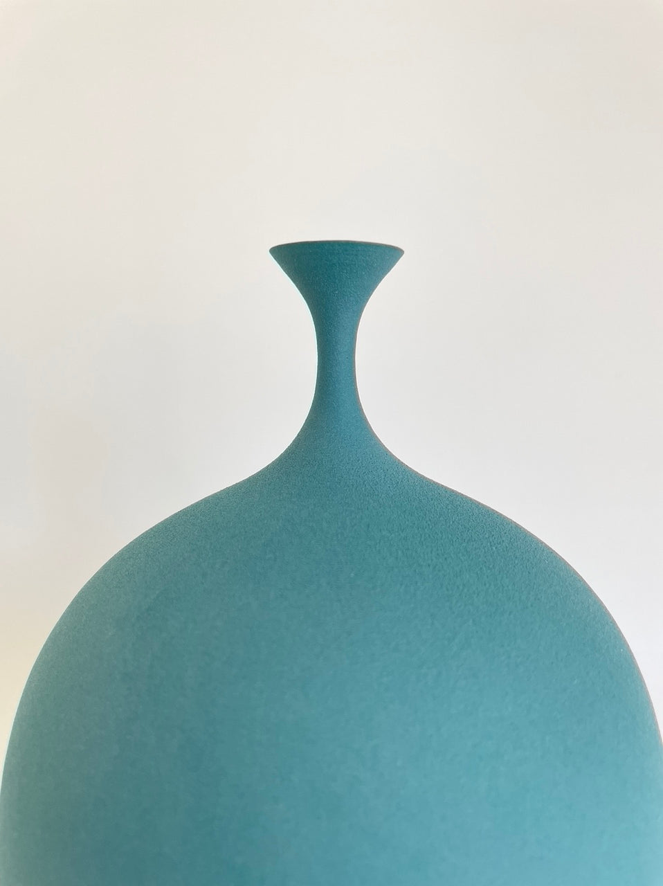 Teal porcelain vessel with narrow spout by Sophie Cook