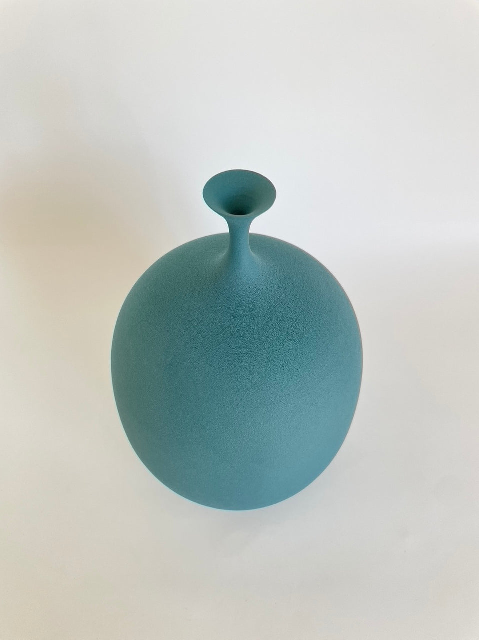 Teal porcelain vessel with narrow spout by Sophie Cook