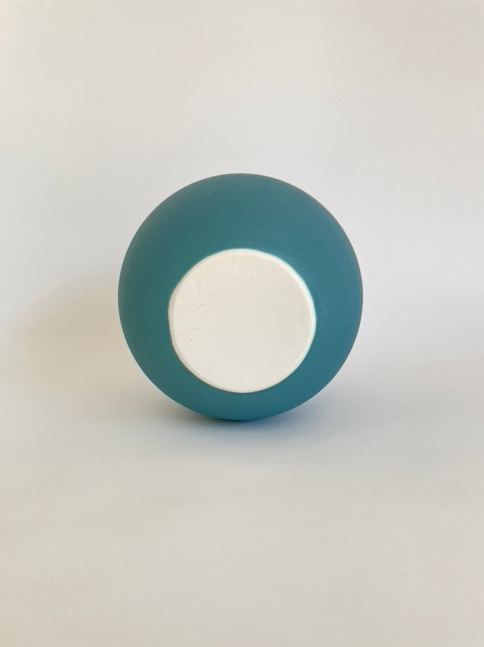 Underside of teal porcelain vessel with narrow spout by Sophie Cook