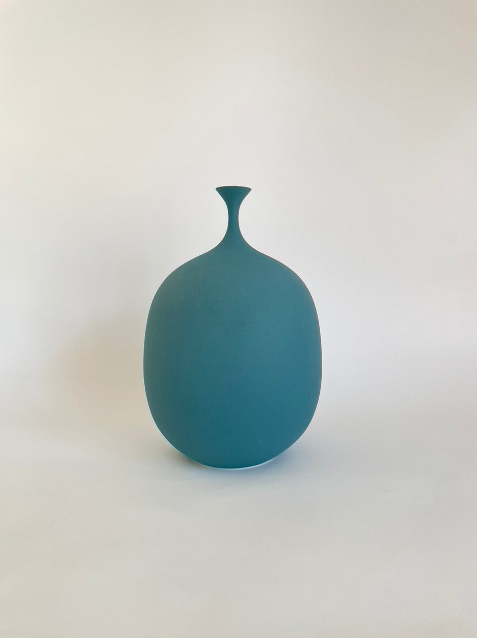 Teal porcelain vessel with narrow spout by Sophie Cook